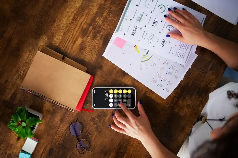 Imagem que ilustra a gestão financeira para empreendedores, com uma calculadora, relatórios e anotações em um ambiente de trabalho organizado.